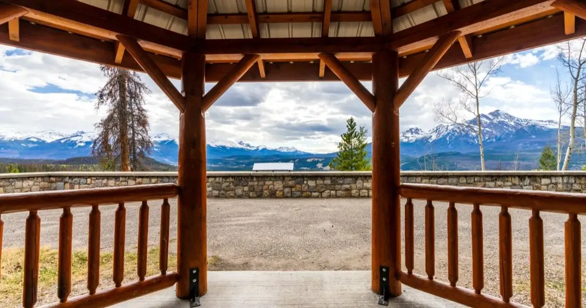 Timber pavilion overlooking a scenic mountain landscape.